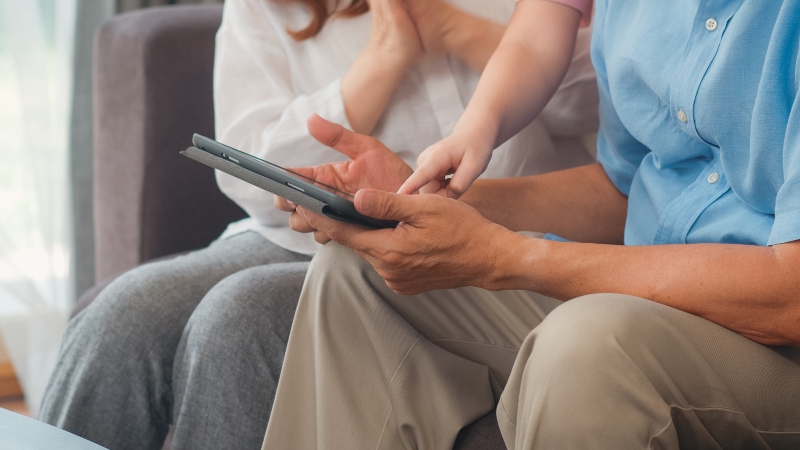 Family looking at old photos and digital memories on devices together
