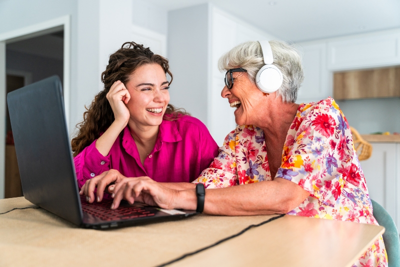 Young woman and elderly mother working together on family digital emergency plan