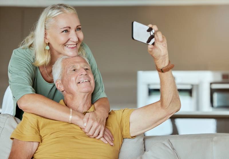 Elderly couple taking selfie together with smartphone