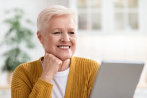 Elderly woman smiling while using technology confidently