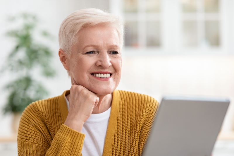 Elderly woman smiling while using technology confidently