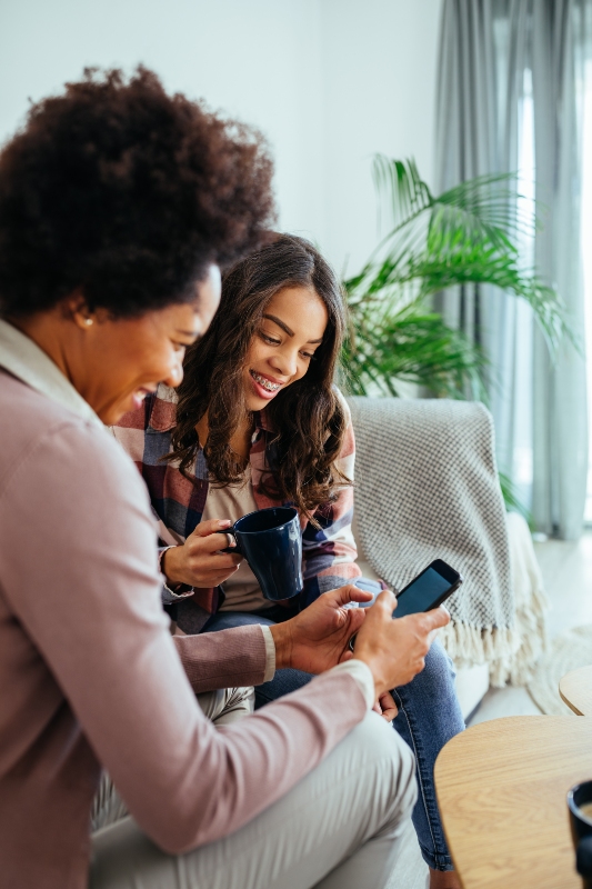Two women collaborating on estate planning using laptop computer, solving sibling estate planning conflicts