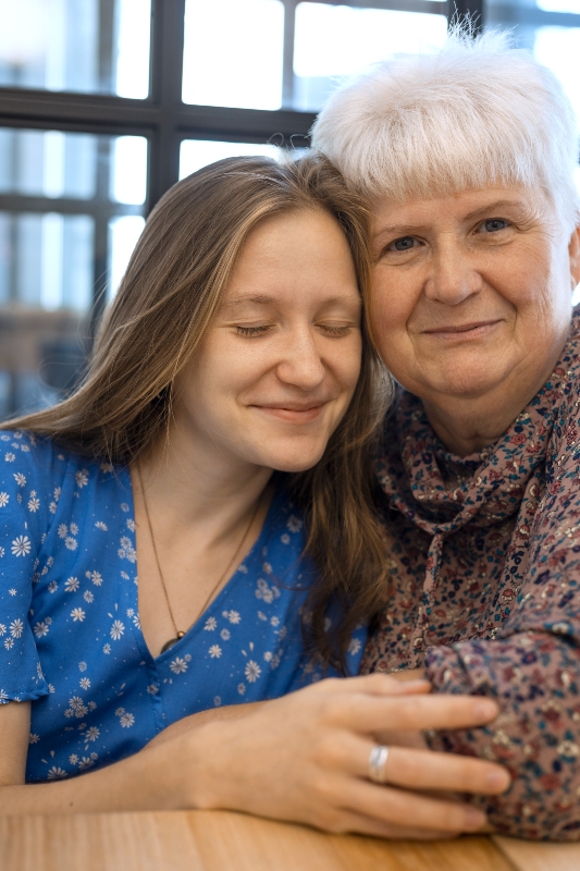 Happy grandmother and granddaughter embracing showing positive family relationship