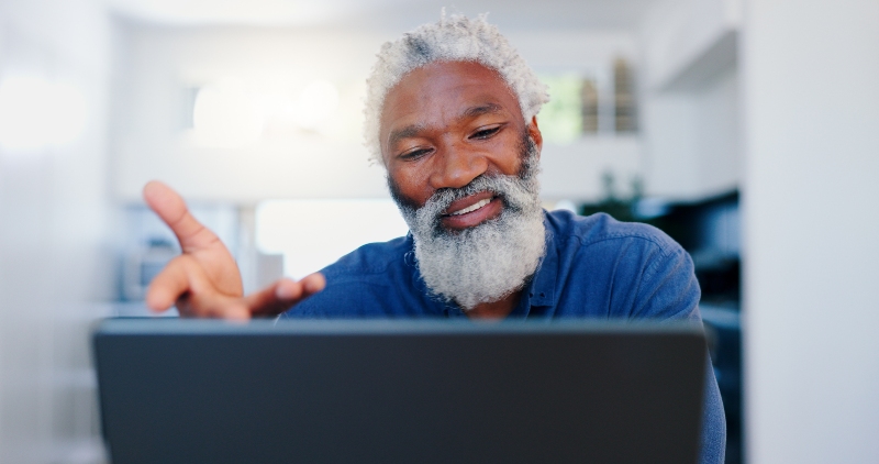Senior man working confidently on laptop computer
