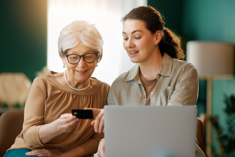 Adult child having calm conversation with elderly parent about technology